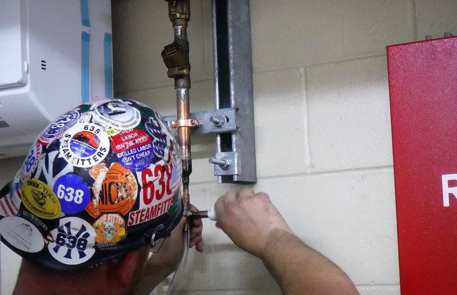 Fontanero soldando una tubería de cobre durante una reparación en Leganés